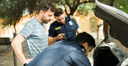 police officers searching a car trunk